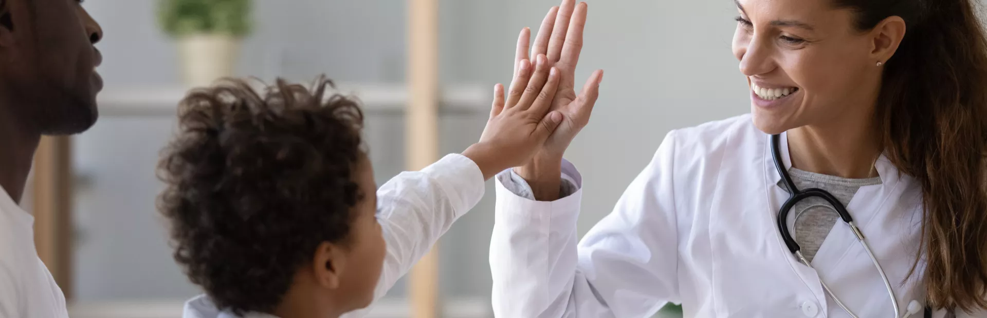 Un niño chocando la mano con su doctora