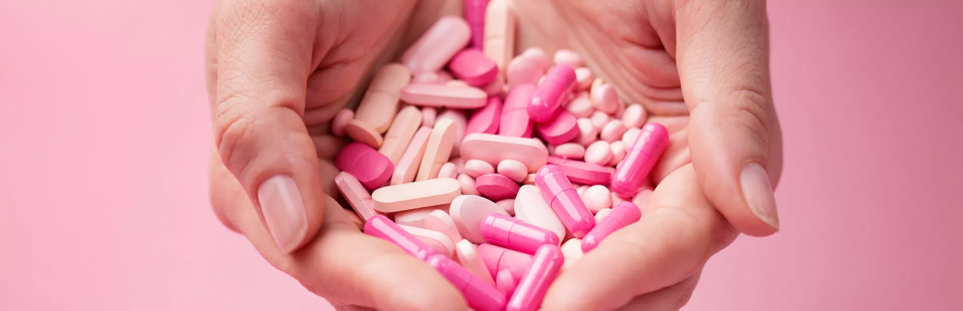 manos sujetando pastillas rosas