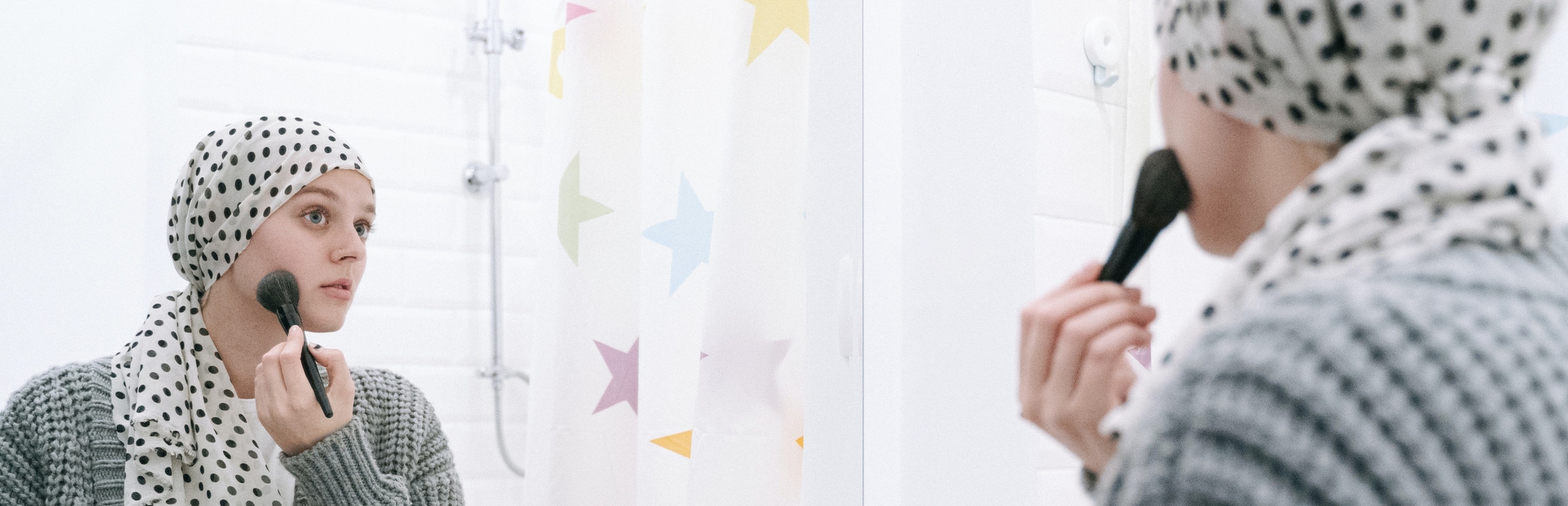 Paciente con cáncer arreglándose frente al espejo