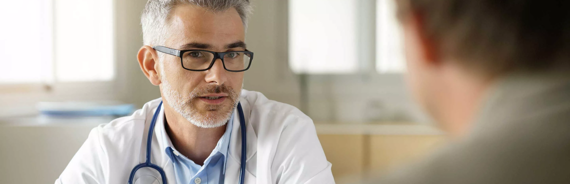 Doctor en consulta médica explicando algo a un paciente