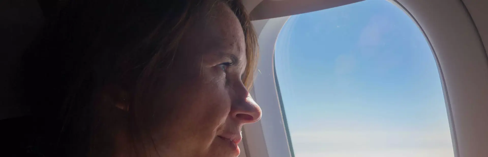 Mujer viendo a través de la ventana del avión