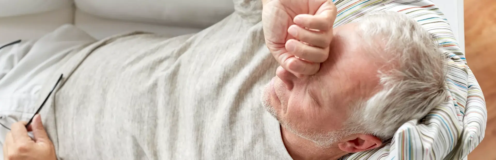 Hombre agotado y recostado en el sofá 