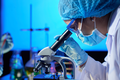 Científica observando a través de un microscopio
