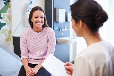 Doctora y pacientes sonriendo en consulta 
