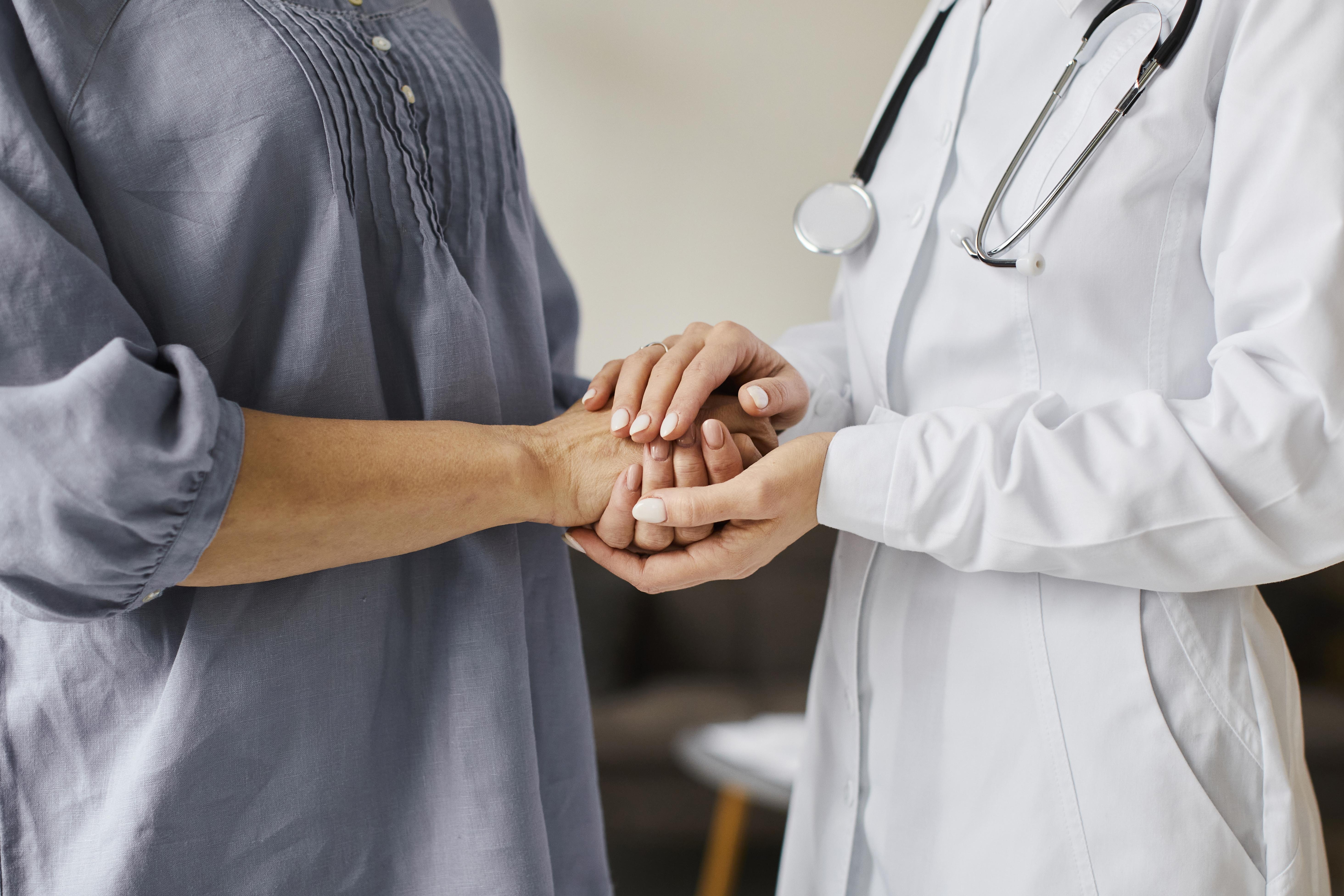 doctora sujetando las manos a su paciente