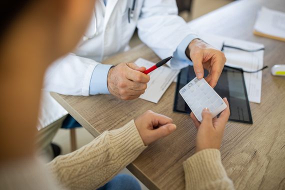 Doctor brindando receta médica a una paciente