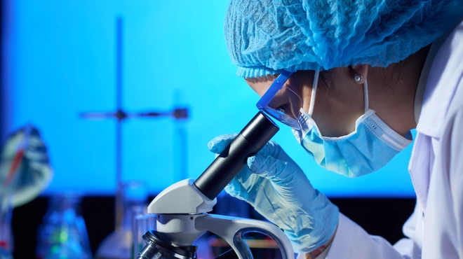 Científica observando a través de un microscopio