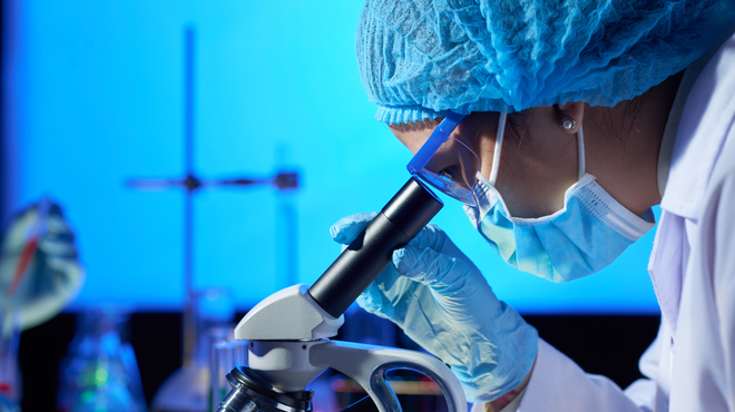 Científica observando a través de un microscopio