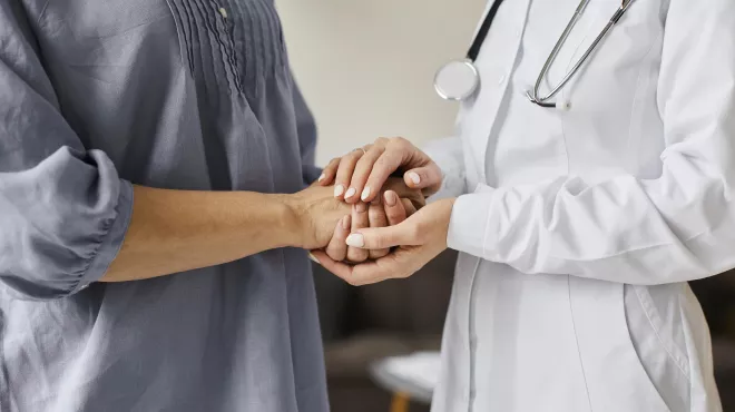 doctora sujetando las manos a su paciente