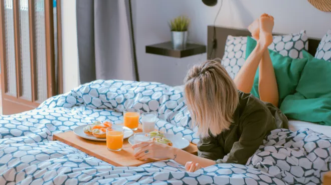 Mujer desayunando en la cama