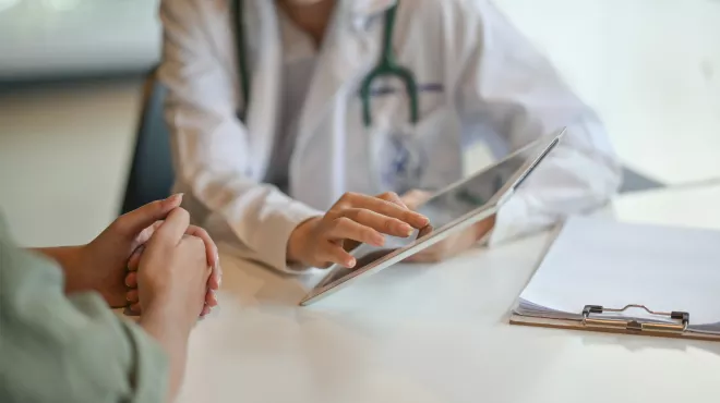 Paciente en consulta con su médico mirando una tablet