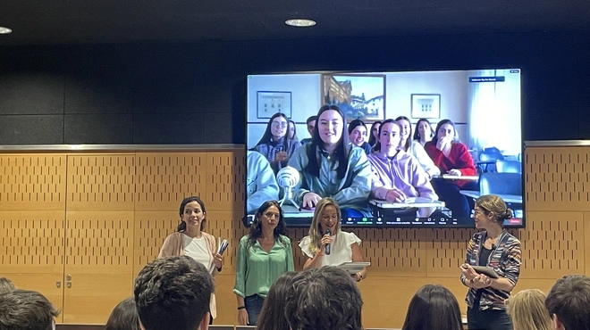 El jurado anunciando el premio y varios miembros del eguipo ganador detrás, en pantalla, conectados vía streaming desde Antequera. Las miembros del jurado son, de izquierda a derecha, Gabriela Garcia, del parque Científico y Tecnológico Cartuja; Charo Cobano, de Fundación Pública Andaluza Progreso y Salud; y Ana Escacena, de Novartis.