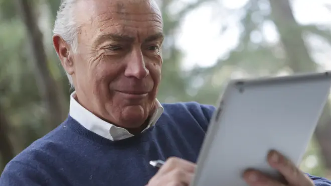 Hombre con jersey azul firmando documentos
