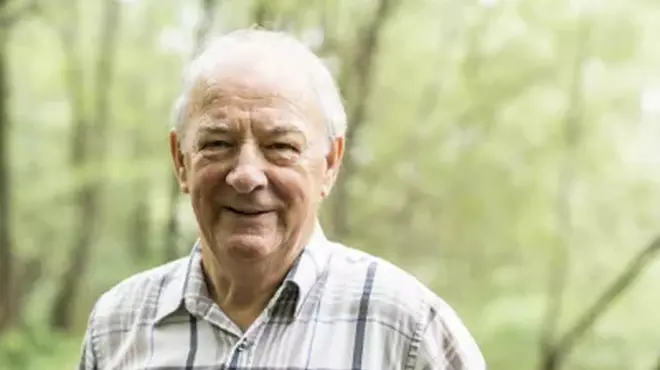 Un adulto mayor sonriendo al aire libre