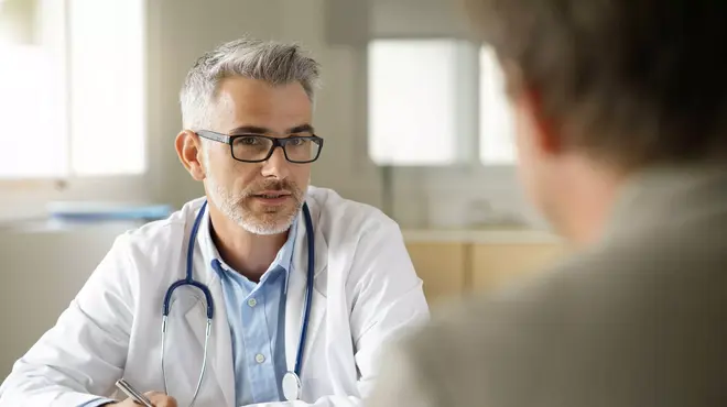 Doctor en consulta médica explicando algo a un paciente