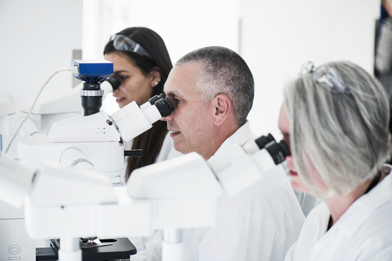 Scientists looking at microscope