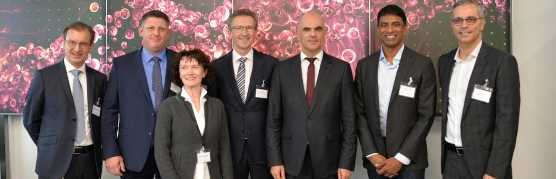Group photo of Novartis Executives together with Federal Councillor Alain Berset in front of the Wall of Hope.
