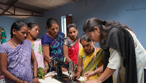 A group of women around a tailoring machine