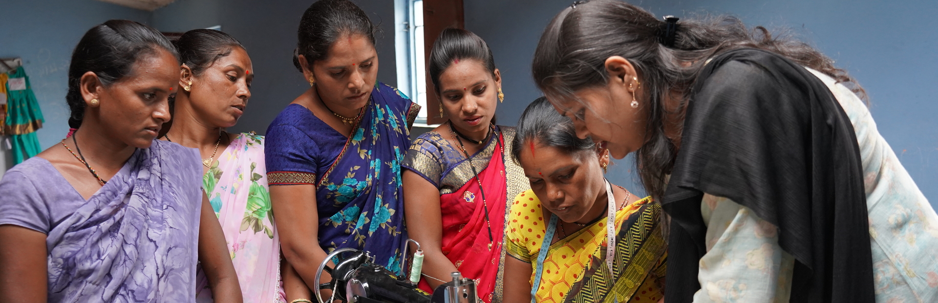 A group of women around a tailoring machine