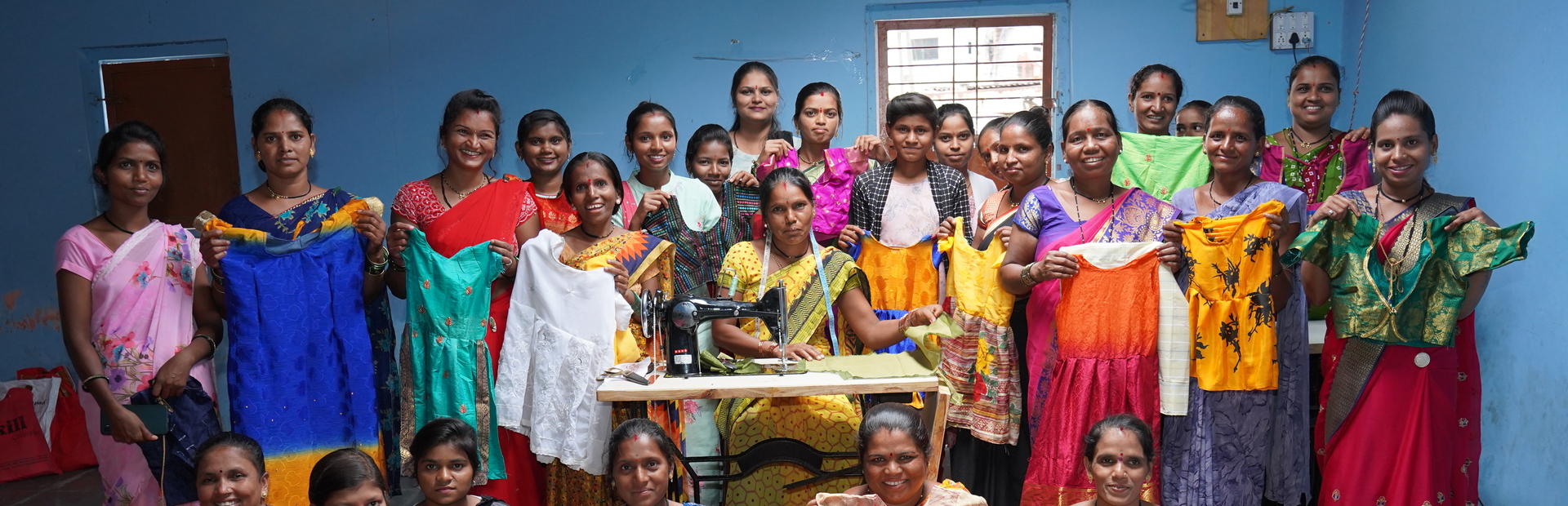 A group of women with the clothes they sewed