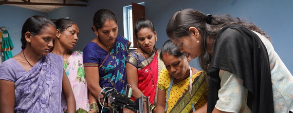 A group of women around a tailoring machine