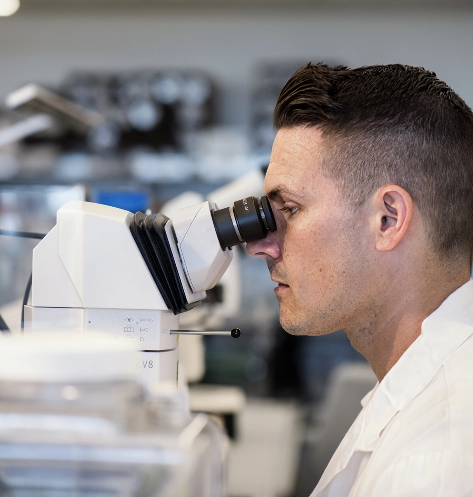 Scientist examining samples with a microscope in a laboratory