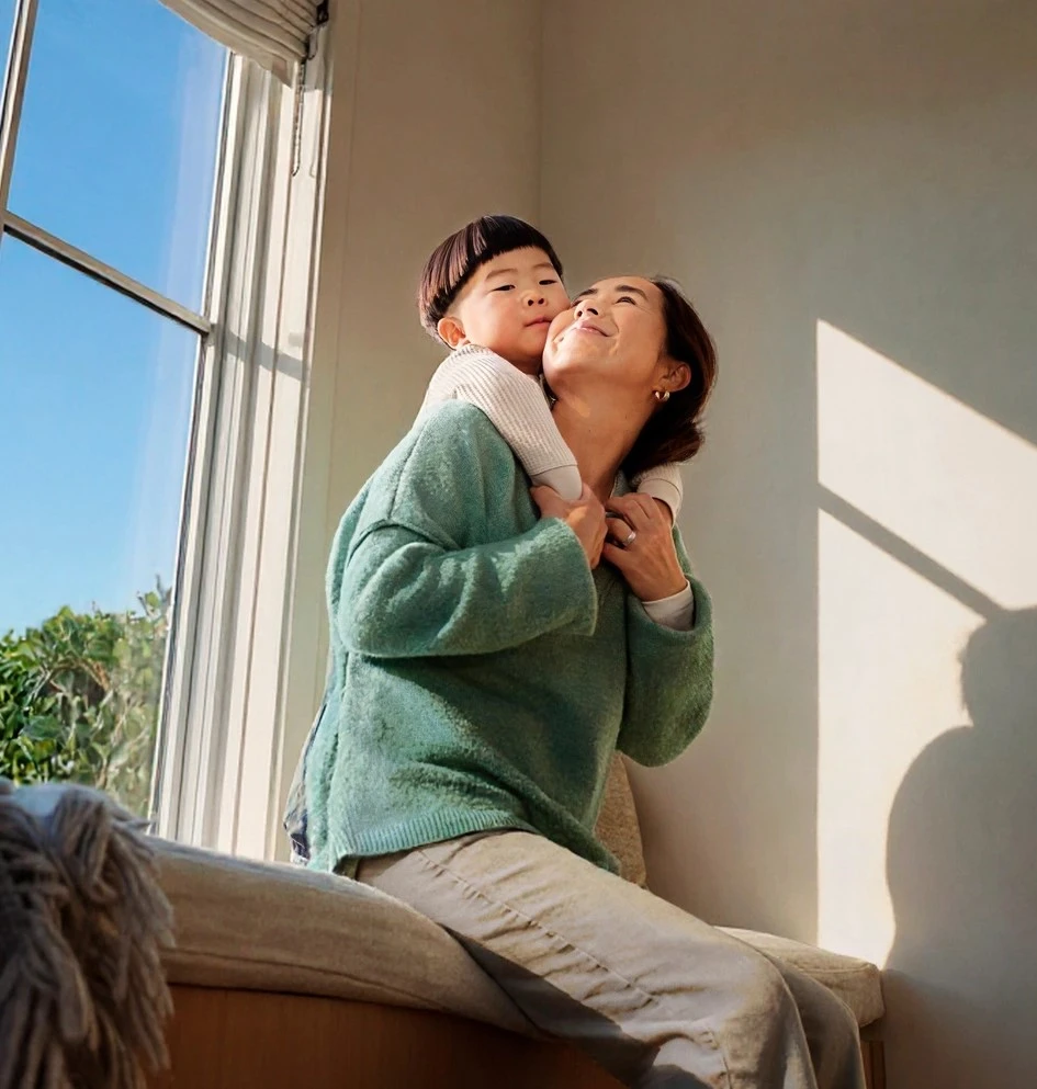 mother-child-cuddling-window-home