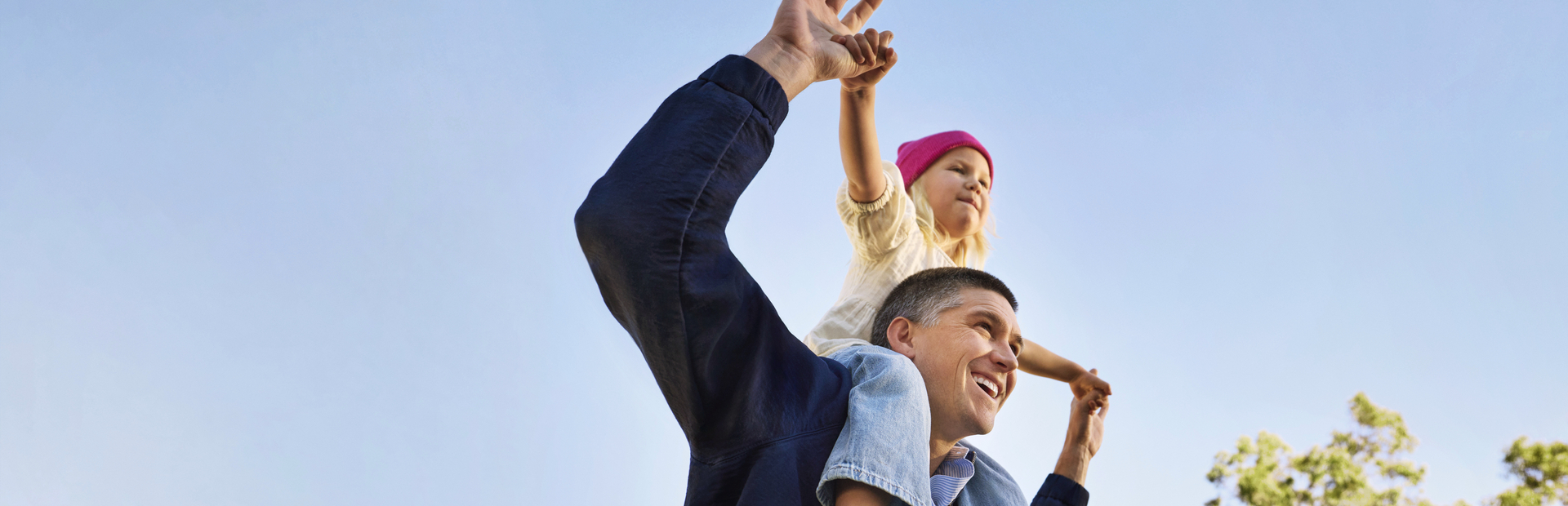 happy-parent-with-child-on-shoulders-under-clear-sky--1-