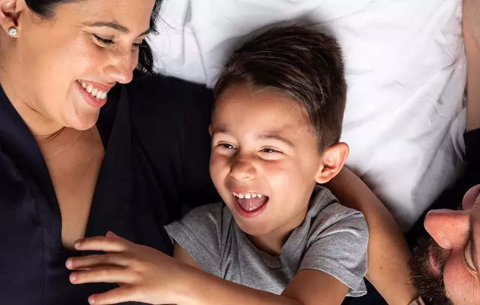 parents-snuggling-with-son-sma