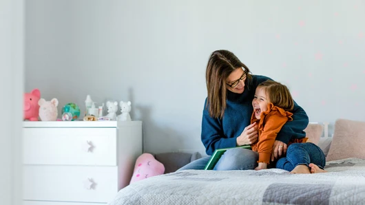 A woman holding a child on the bed