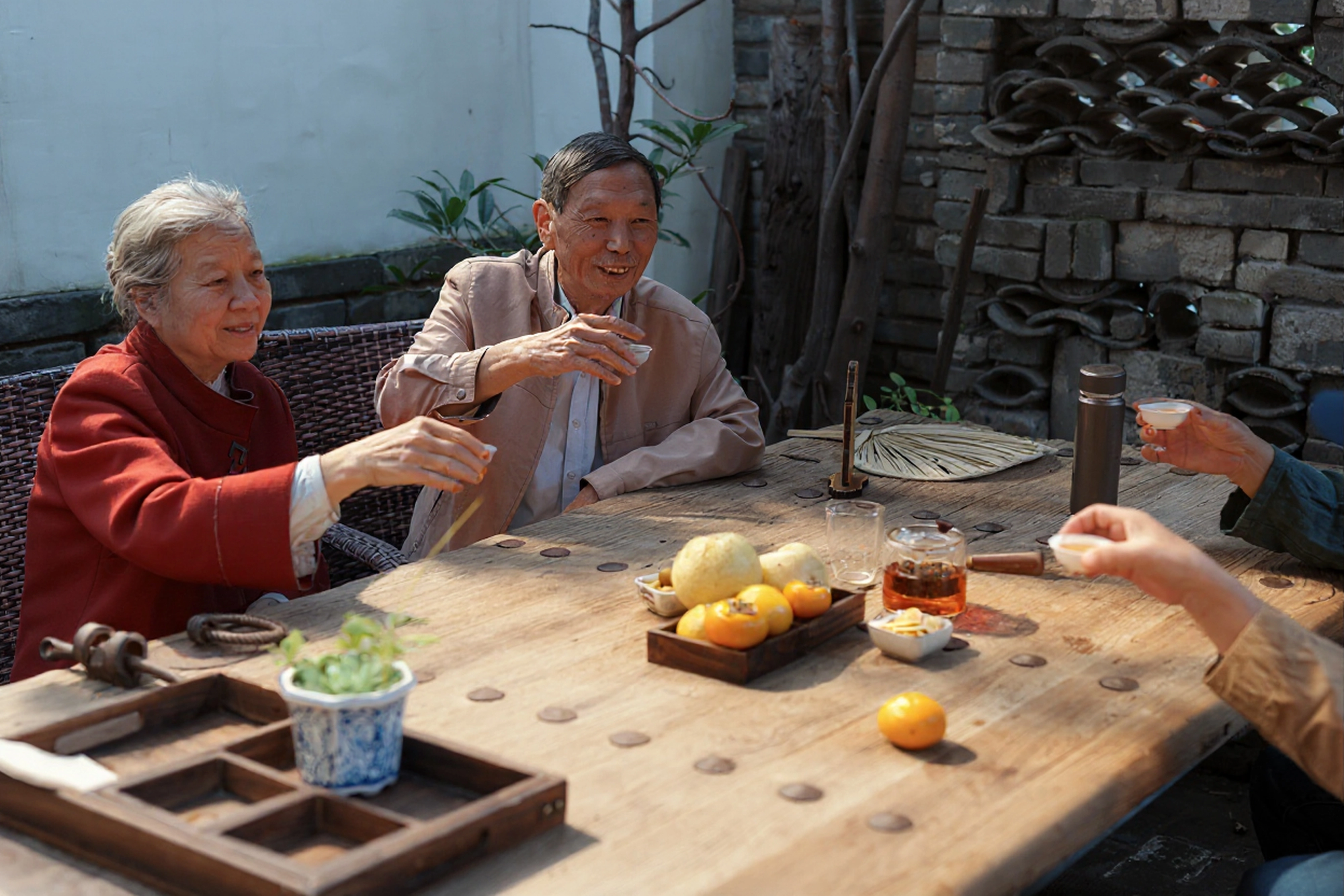 family-enjoying-tea-together-outdoors-at-a-wooden-table