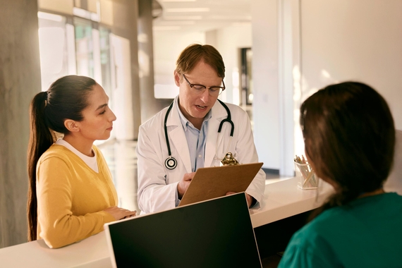 Doctor consulting with a patient at reception desk