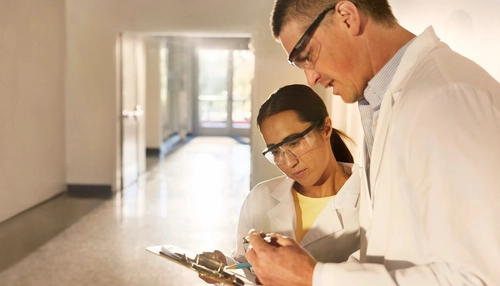 Twee zorgverleners kijken samen naar een rapport