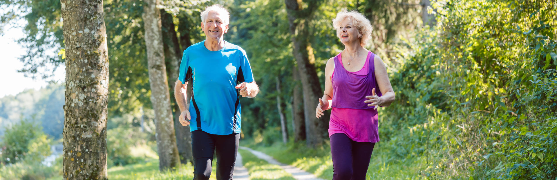 Twee senioren joggen in een bos