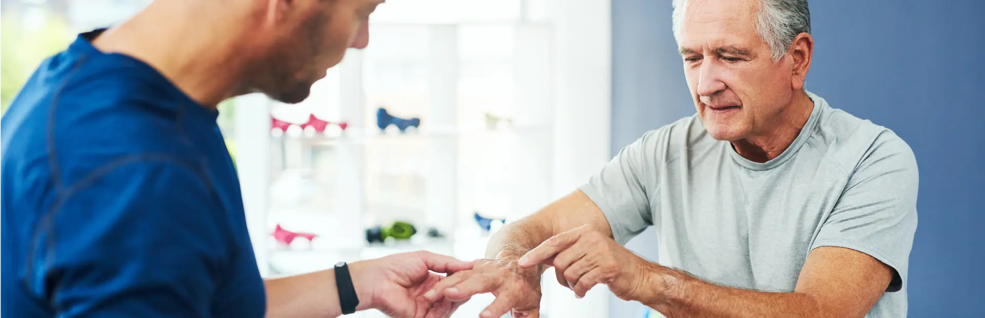 Arts onderzoekt hand van oudere patient