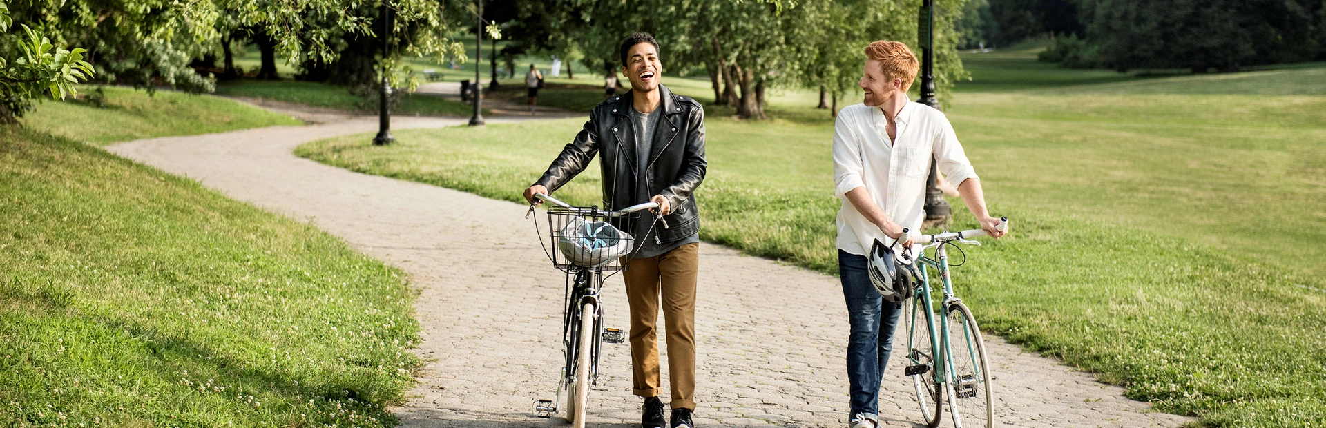 Twee vrienden lopen in de natuur naast hun fietsen