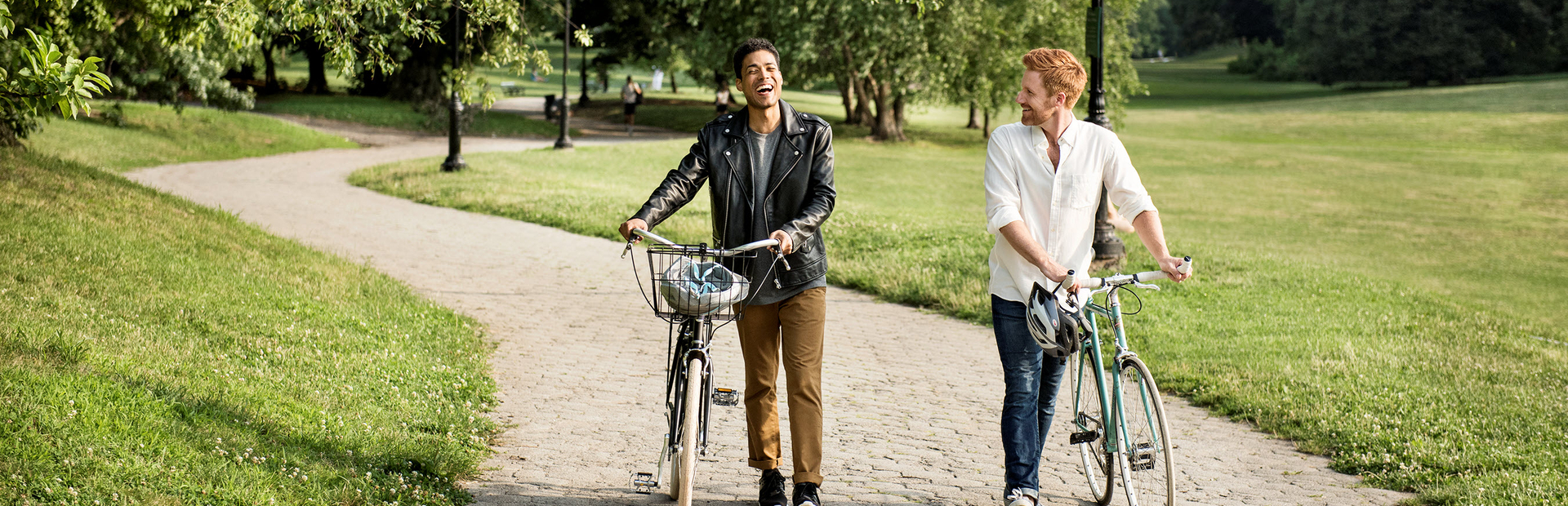 Twee vrienden lopen in de natuur naast hun fietsen