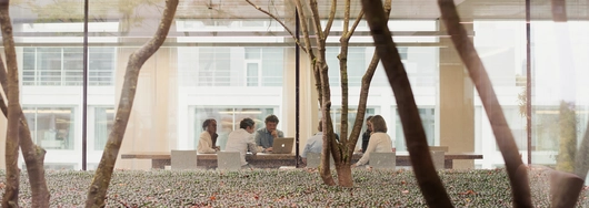 Groep mensen aan een tafel met een laptop