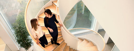Twee collega's lopen een moderne wenteltrap af