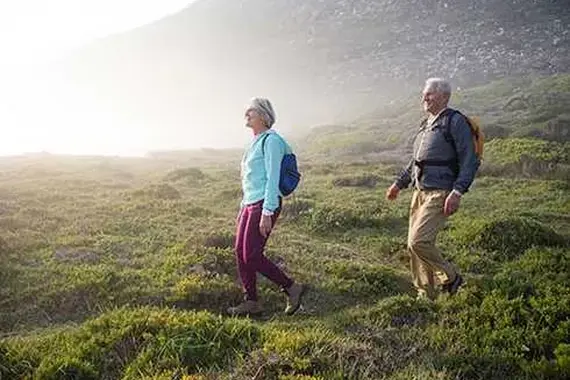 Ouder stel wandelt in heuvelachtig landschap