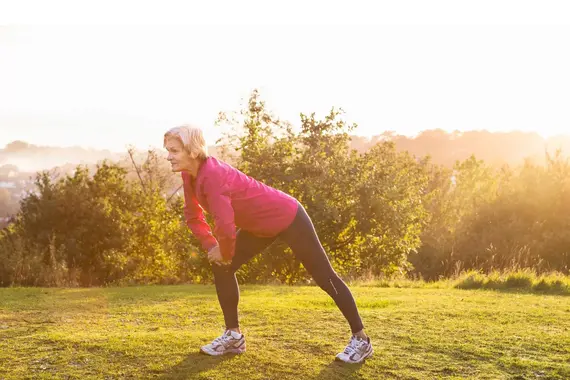 Oudere vrouw strecht in de buitenlucht
