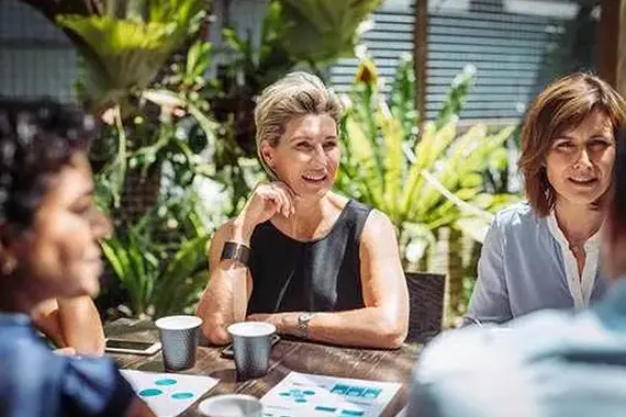Groep vrouwen samen aan tafel in de buitenlucht