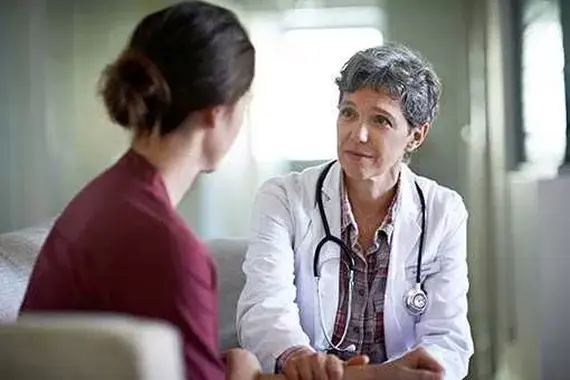 Arts spreekt met vrouwelijke patiente