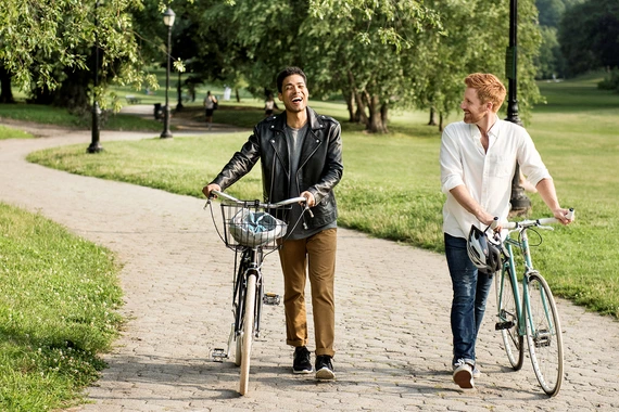 Twee vrienden lopen in de natuur naast hun fietsen
