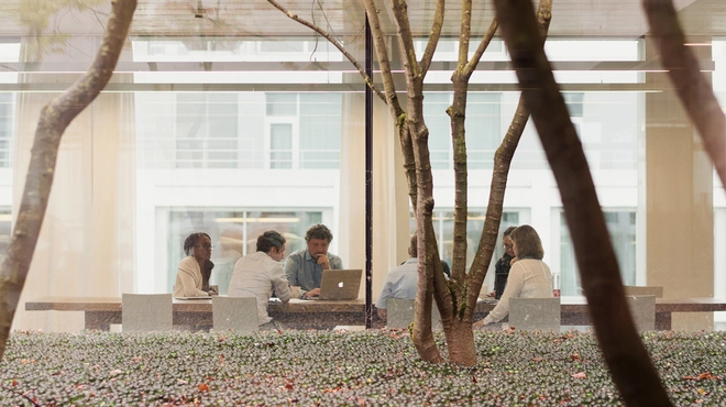 Groep mensen aan een tafel met een laptop
