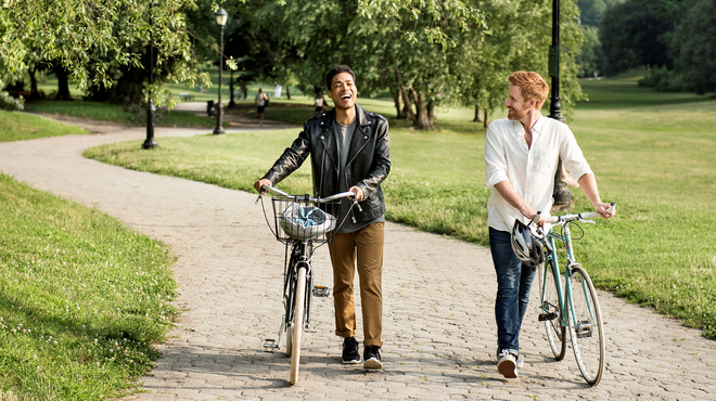 Twee vrienden lopen in de natuur naast hun fietsen