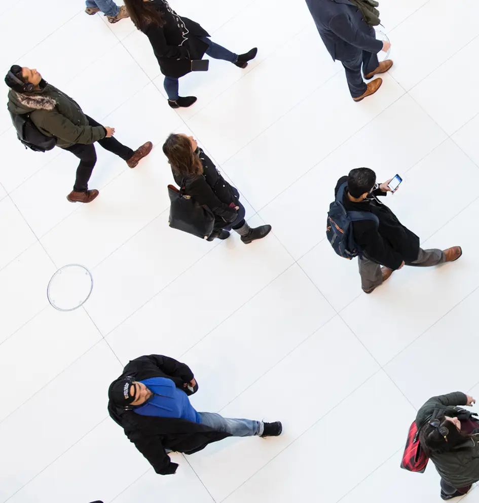 Vedere aeriană cu oameni mergând prin holul alb al unei clădiri moderne