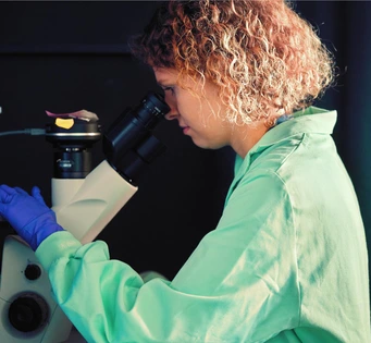 Om de știință care folosește un microscop într-un laborator