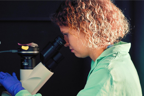 Om de știință care folosește un microscop într-un laborator