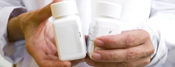 Zdravstveni radnik drži dve bočice lekova